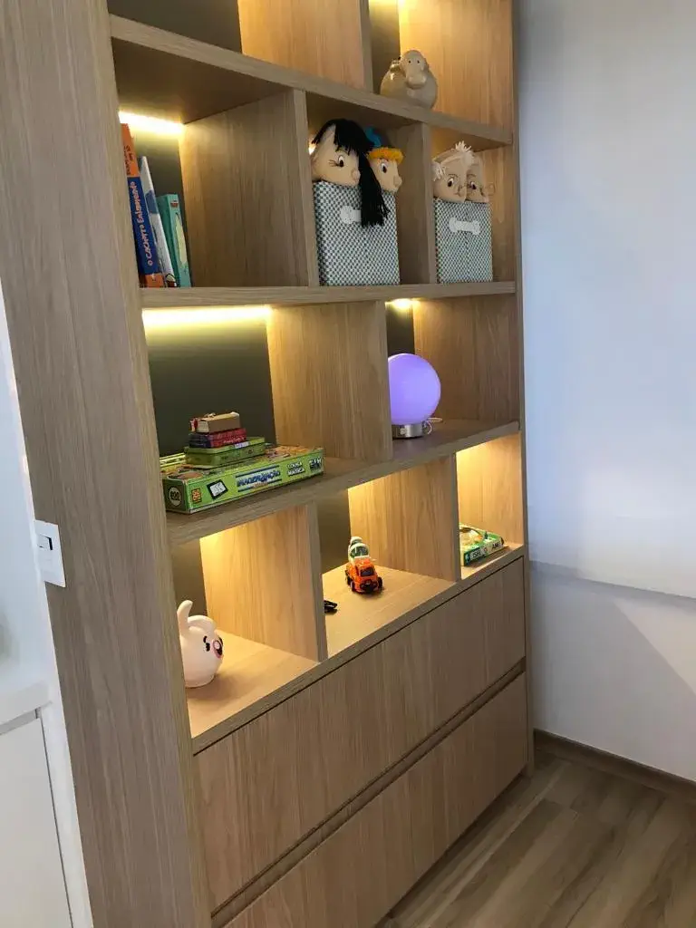 Estante iluminada com brinquedos, livros e fantoches para terapia