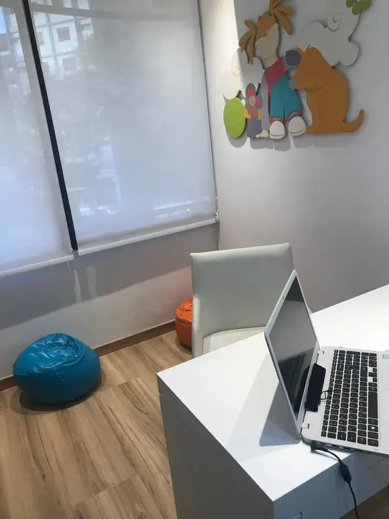 Área de trabalho com puffs coloridos e decoração infantil na parede